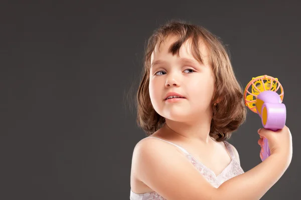 Маленька дівчинка грає з вентилятором — стокове фото