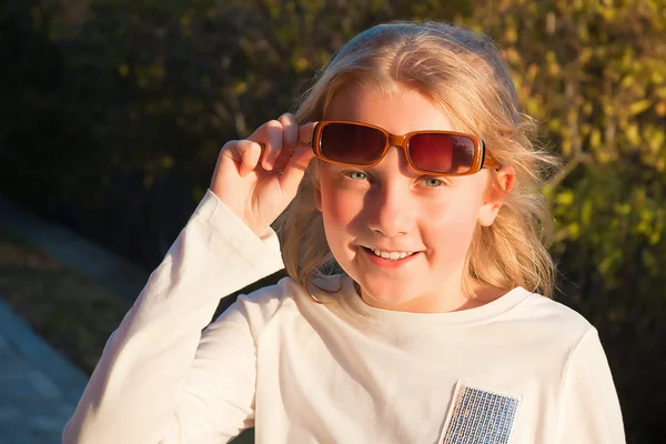Sorrindo menina adolescente vestindo óculos ao ar livre — Fotografia de Stock