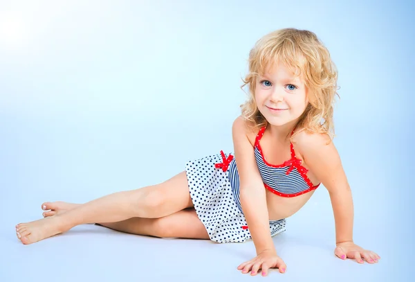 Adorable smiling playful girl 4 years old lying on blue studio b — Stock Photo, Image
