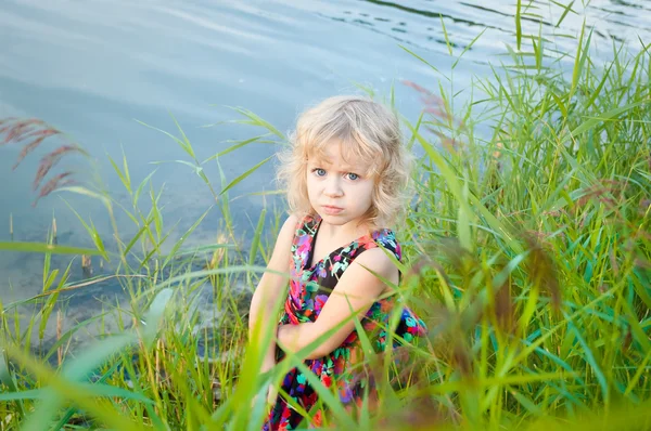 Mała dziewczynka plaing sam w riverside — Zdjęcie stockowe