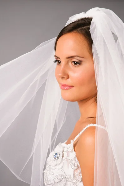 Schöne Braut unter Schleier auf neutralem Hintergrund im Studio — Stockfoto