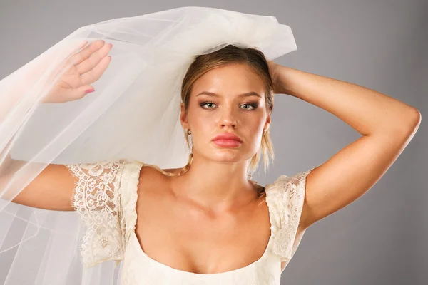 Sposa eccitata indossa un velo in studio — Foto Stock