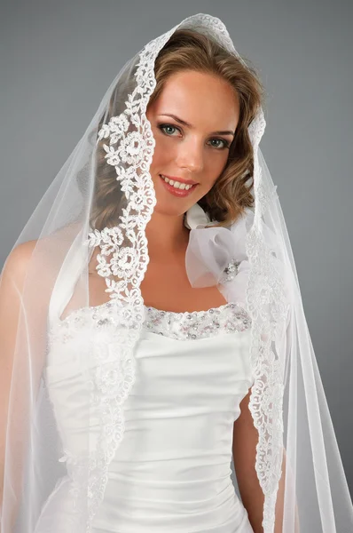Ritratto di bella sposa sotto un velo in studio — Foto Stock