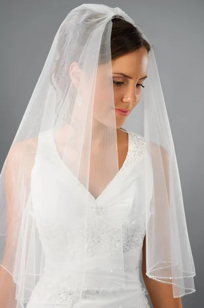 Schöne Braut unter Schleier auf neutralem Hintergrund im Studio — Stockfoto
