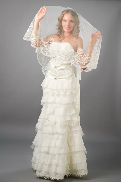 Schöne Braut unter Schleier Kleid auf dem neutralen Hintergrund — Stockfoto