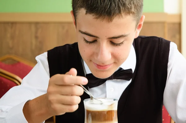 En tonåring pojke njuter av kaffe på ett kafé — Stockfoto