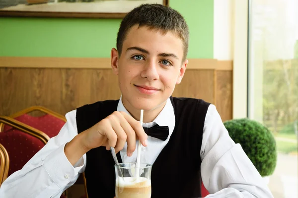 Мальчик-подросток, наслаждающийся кофе в ресторане — стоковое фото
