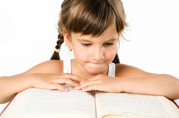Menina bonito à procura de informações em um grande livro isolado em branco — Fotografia de Stock