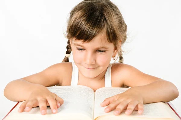 Niedliches Mädchen auf der Suche nach Informationen in einem großen Buch isoliert auf weiß — Stockfoto