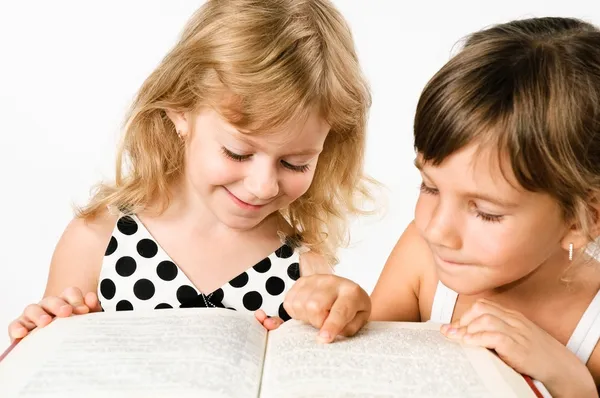 Zwei Vorschulmädchen lesen ein Buch isoliert auf weiß — Stockfoto