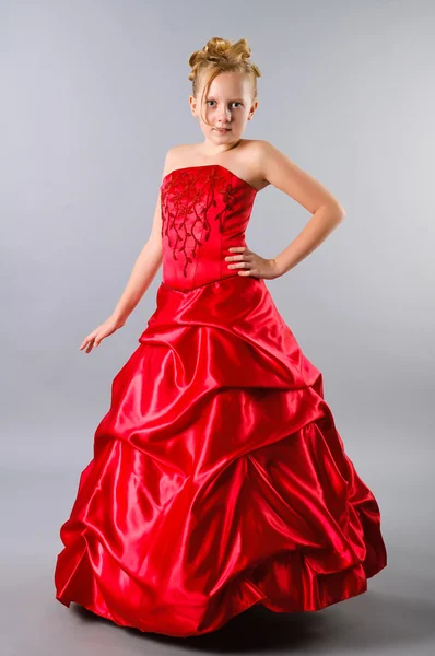 A cute blond teenage girl posing in a prom dress on studio neutral backgrou — Stock Photo, Image