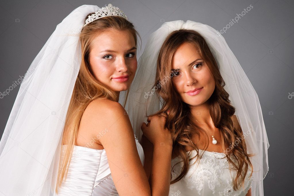 Two pretty brides wearing wedding dresses and veils