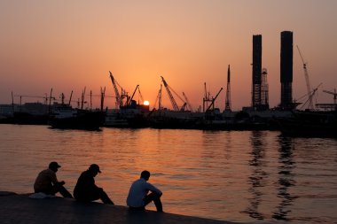 Workers rest in the port Sharjah. clipart