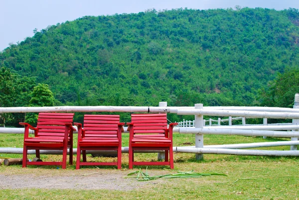 Červené dřevěné židle v zemědělské půdě — Stock fotografie