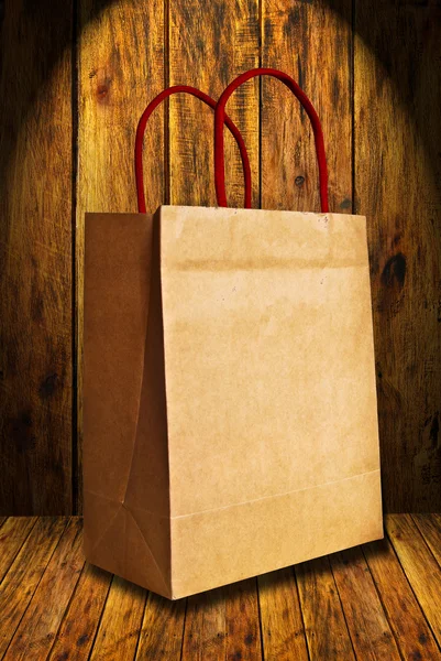 stock image Brown shopping bag on wood background