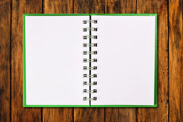 在木材上的空白绿色封面笔记本 — 图库照片