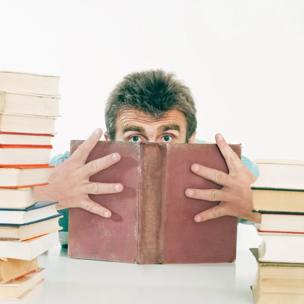 De persoon verbergt het gezicht achter het oude boek. — Stockfoto