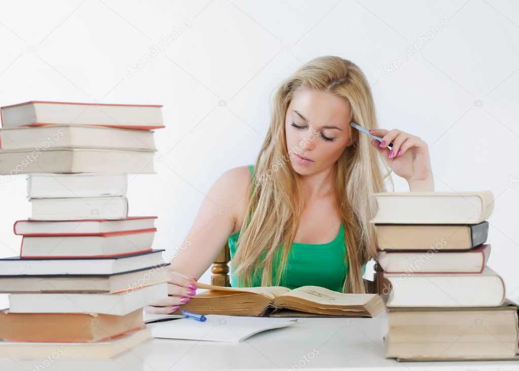 Young student woman with lots of books studying for exams.