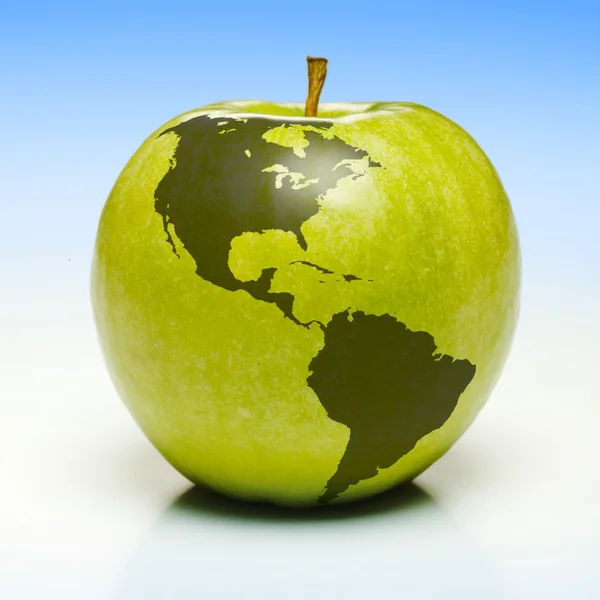 Зеленое яблоко с картой земли — стоковое фото