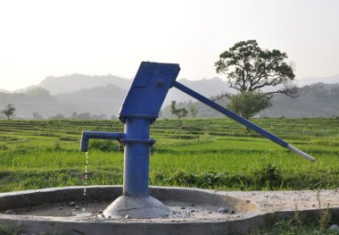 A Water Pump in a Beautiful Field in India clipart