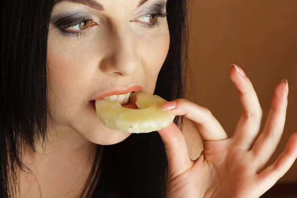 Woman bitting pineapple — Stock Photo, Image