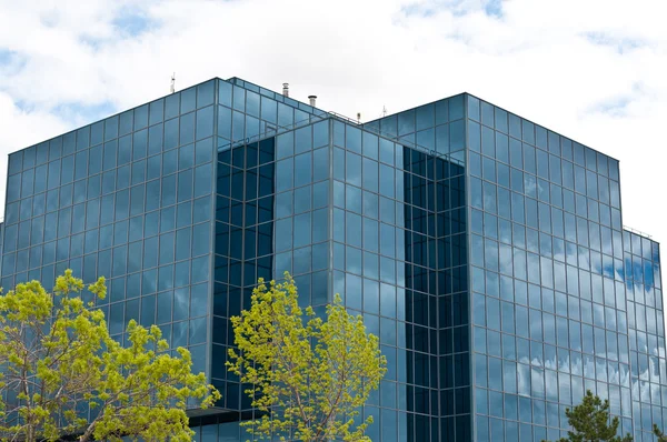 Edificio per uffici con alberi e nuvole — Foto Stock