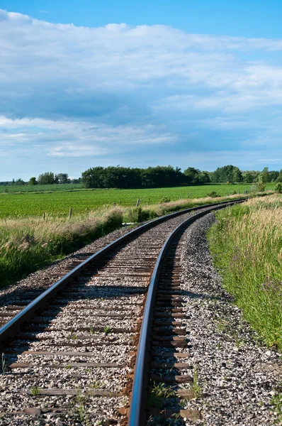Binari ferroviari curva fuori in lontananza — Foto Stock
