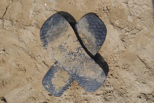 Slippers als x op het zand — Stockfoto