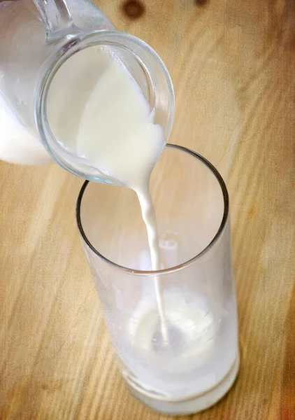 Stromen van de melk in een glas — Stockfoto