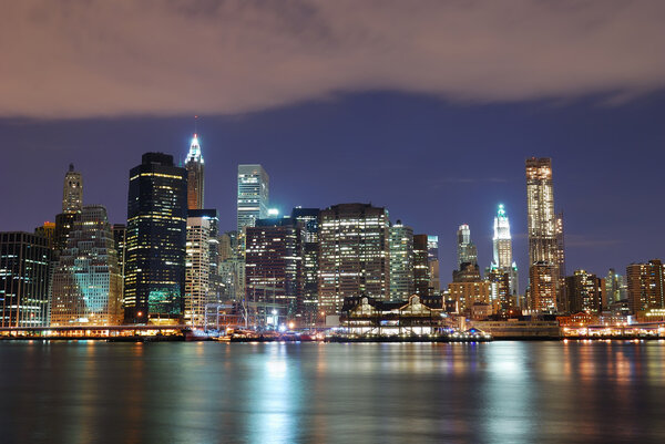 New York City Manhattan skyline with office skyscrapers building in at dusk illuminated with lights at night over Hudson River