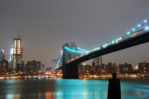 Manhattan skyline and Brooklyn bridge night scene over Hudson river, New York City