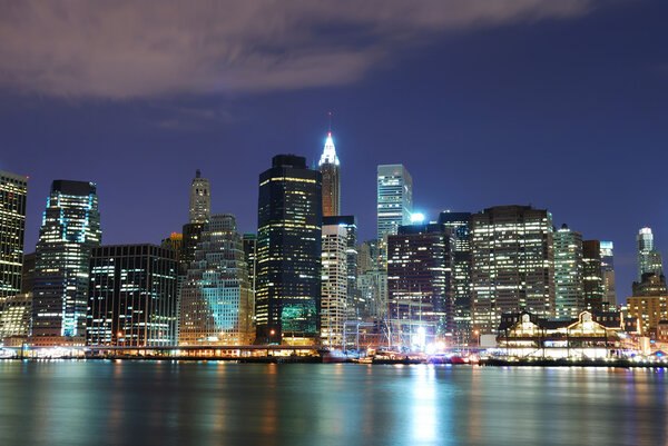 New York City Manhattan skyline with office skyscrapers building in at dusk illuminated with lights at night over Hudson River