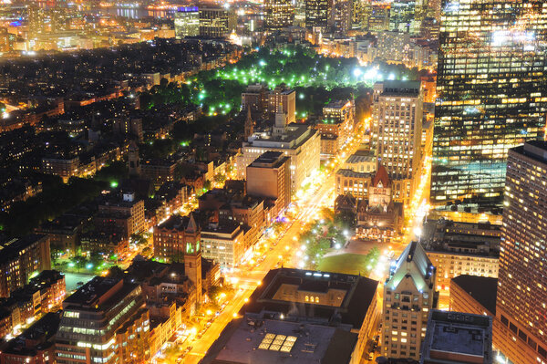 Urban city night scene. Boston aerial view with skyscrapers at night with city skyline illuminated.