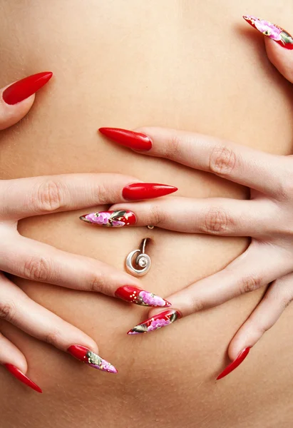 Red nails on tummy — Stock Photo, Image
