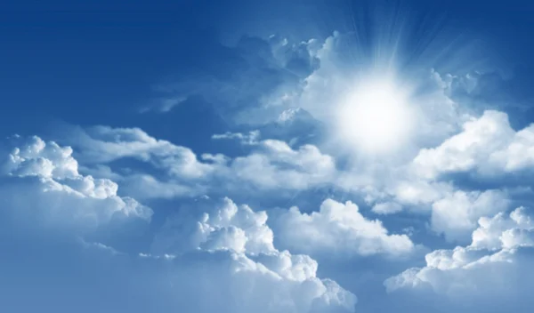 Photo of clouds and sun in the background of a beautiful blue sky — Stock Photo, Image