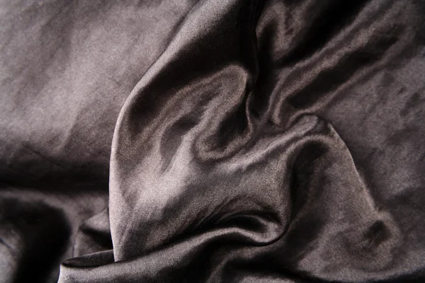 Closeup of folds in crumpled black silk fabric — Stock Photo, Image