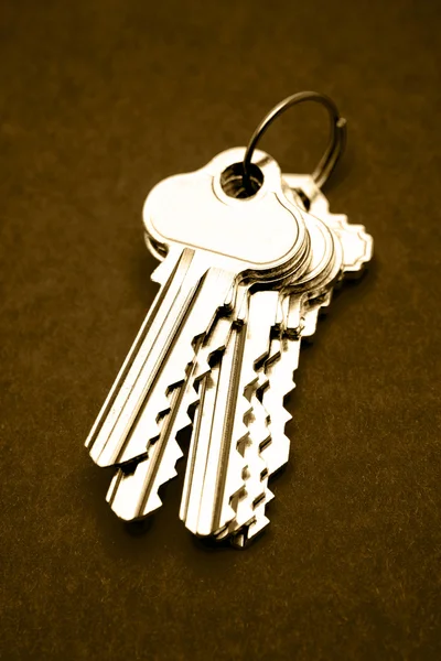 Bando de chaves da casa no fundo marrom — Fotografia de Stock