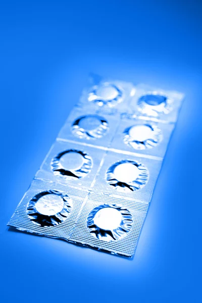 Comprimidos em papel alumínio no azul — Fotografia de Stock