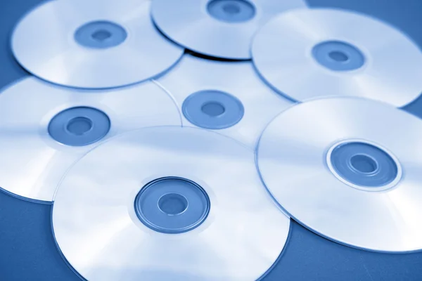 Primer plano de discos compactos en blanco, tono azul — Foto de Stock