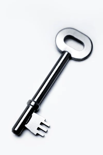 Stary klucz do drzwi na zwykły tło zbliżenie — Zdjęcie stockowe