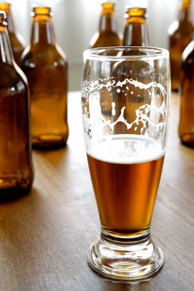 Glas Bier und Flaschen auf dem Tisch — Stockfoto