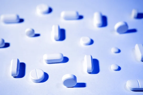 Pillen en tabletten werpen schaduwen, blauwe Toon — Stockfoto