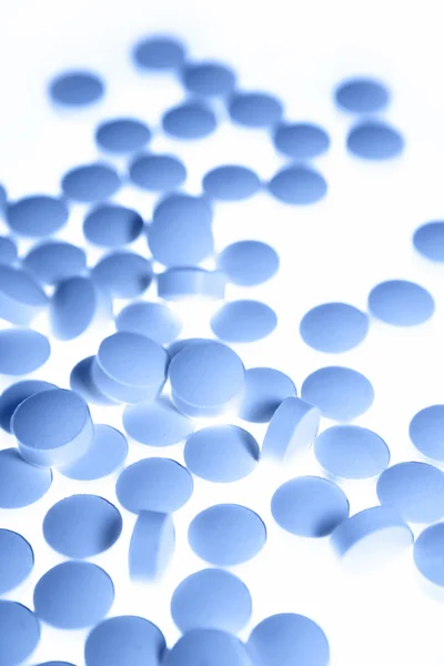 Крупный план голубых таблеток на белом фоне — стоковое фото