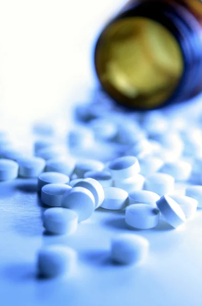 Close-up van pillen morsen uit fles — Stockfoto
