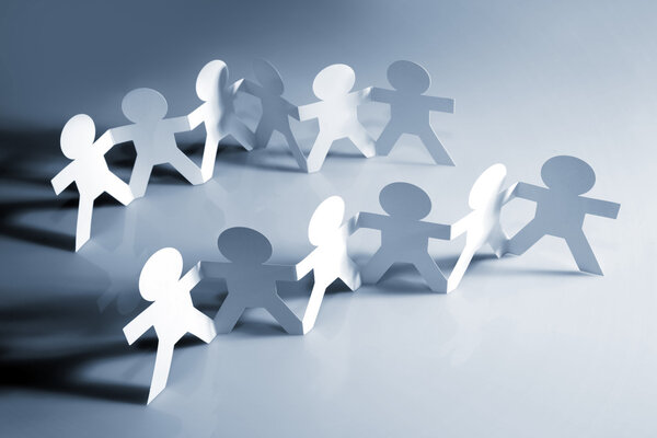 Команды бумажной куклы держатся за руки
