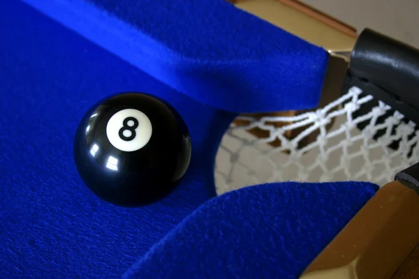 Number eight pool ball on blue pool table next to corner pocket — Stock Photo, Image