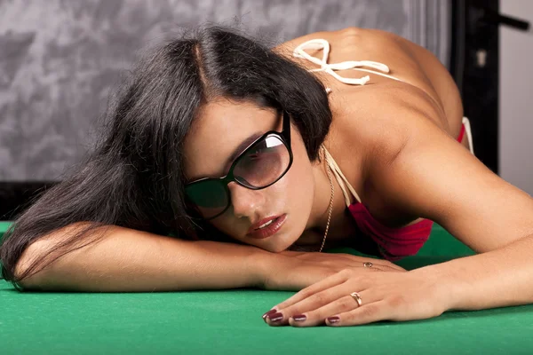 Schöne junge Mädchen im Bikini auf einem Billardtisch — Stockfoto