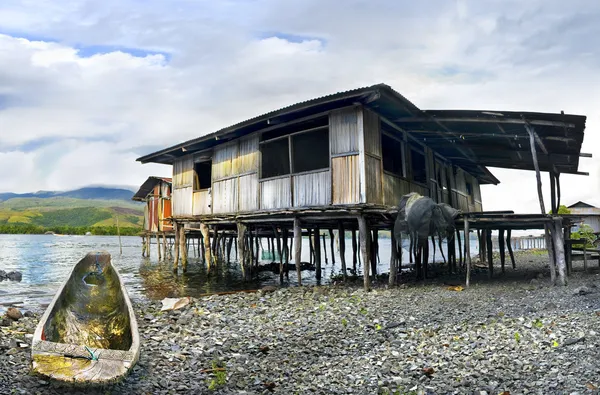 Barco e casa de campo em pilhas em terra lago sentani — Fotografia de Stock
