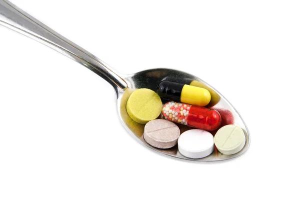 Colher e pílulas Imagem De Stock