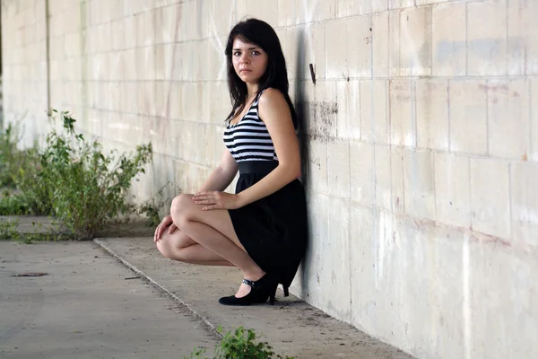 Krásná brunetka v bloku zdi (1) — Stock fotografie